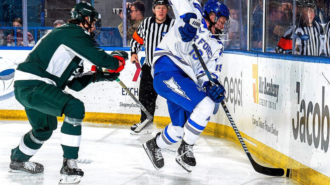 College ice hockey players battling along the boards during a game in Colorado Springs
