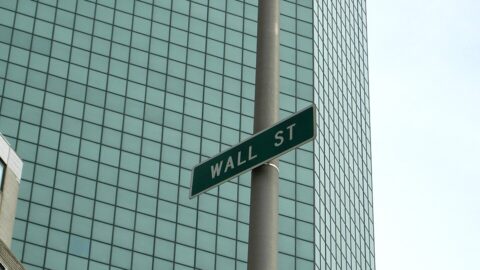 Wall Street street sign against a glass office tower