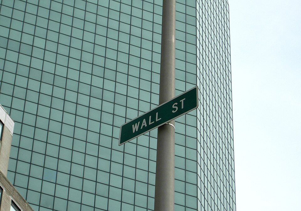Wall Street street sign against a glass office tower